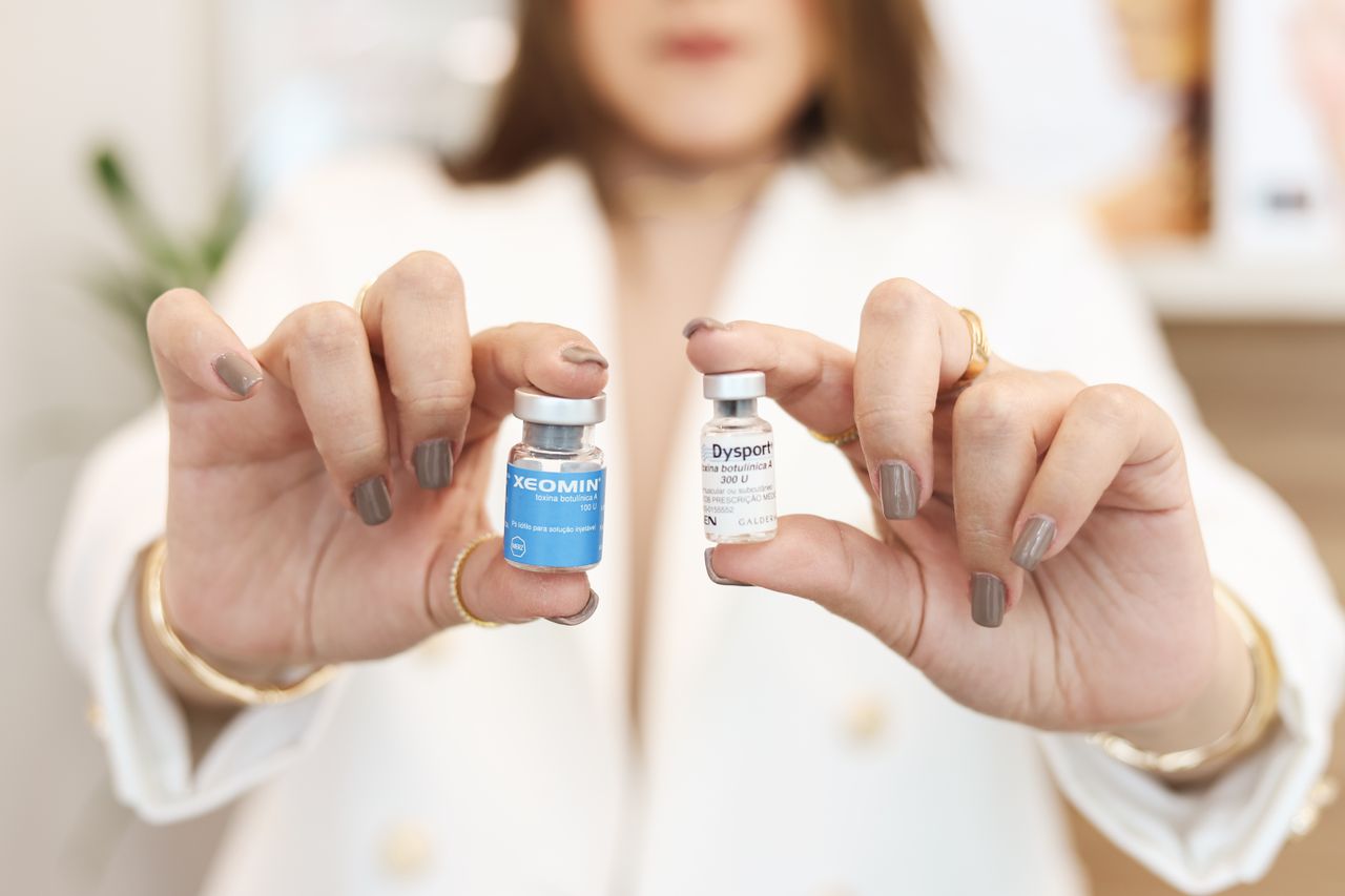 services-04 A close-up of a woman holding Xeomin and Dysport vials, showcasing cosmetic treatment options.